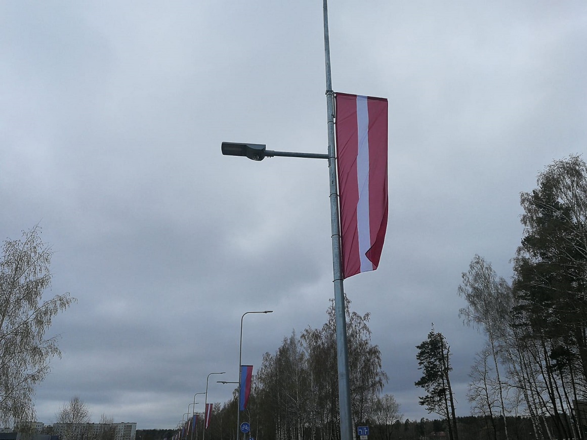 Valsts karoga banneris apgaismes balstā Loka maģistrālē