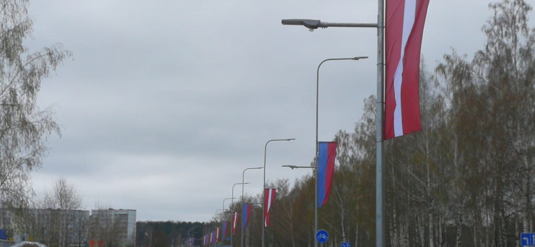 Valsts karoga un Jelgavas valstspilsētas banneri apgaismes balstos Loka maģistrālē