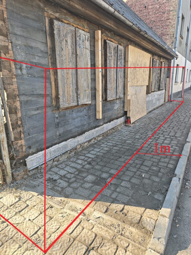 Matera_iela Ietve gar ēku ar iezīmētu 1 metru platu gājēju joslu.