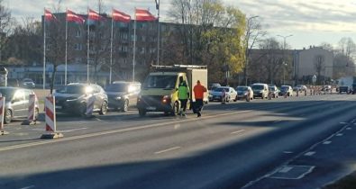 liela-iela_small Ceļa remontdarbi Lielajā ielā pie Hercoga Jēkaba laukuma – satiksme vienā joslā, automašīnu rinda un divi ceļstrādnieki pie darba furgona.