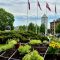 Pilsētas apstādījumu ierīkošana Jelgavā. Priekšplānā puķu dobe, fonā Latvijas karogi un Sv. Trīsvienības baznīcas tornis.