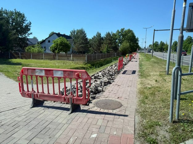 rigas-iela-brugis-1 Gājēju ietves remontdarbi ar uzraktu bruģi, kas norobežoti ar sarkanām plastmasas barjerām.