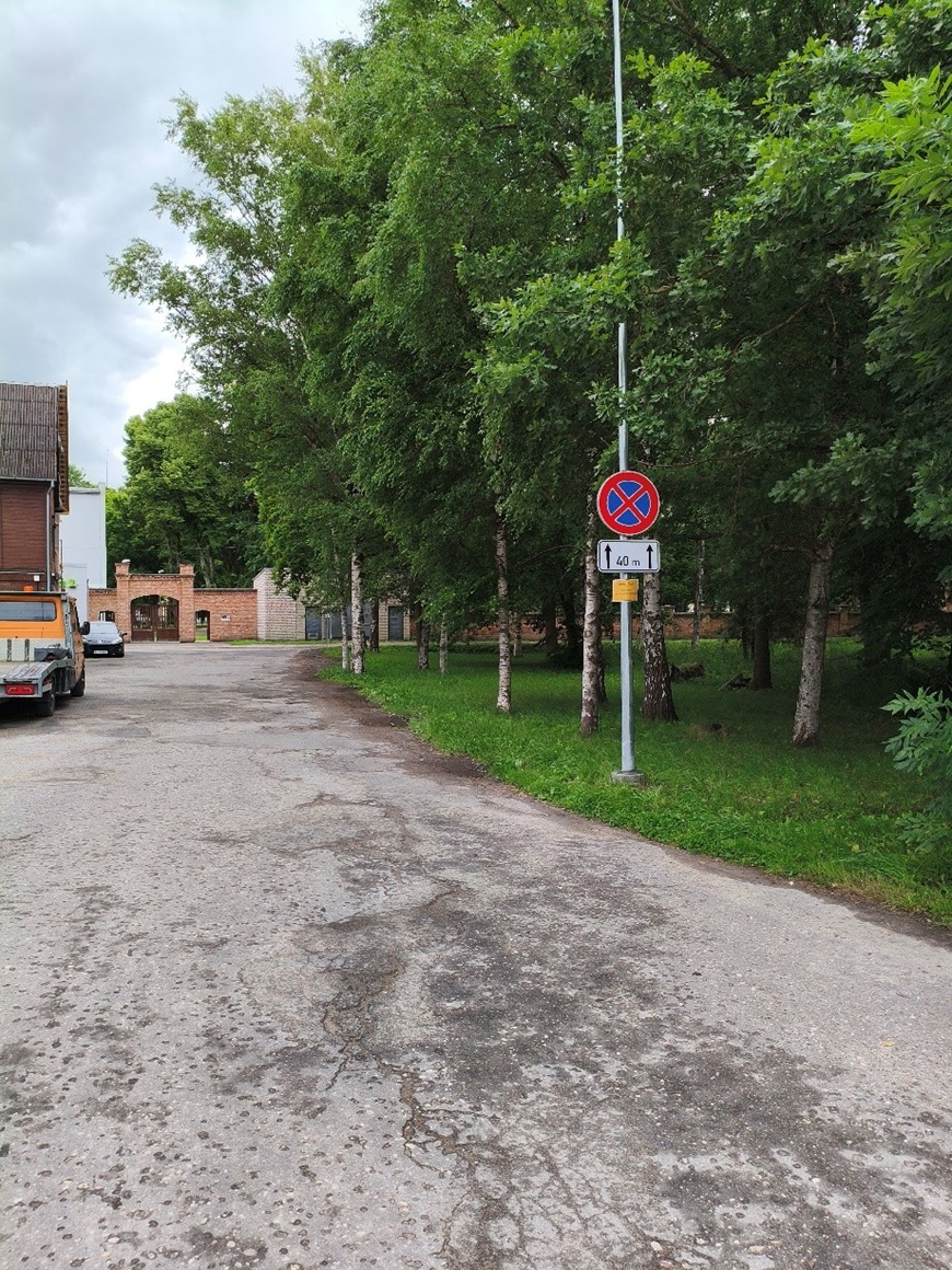Filozofu iela - asfaltēts piebraucamais ceļš gar kokiem. Labajā pusē redzama ceļa zīme “Apstāties aizliegts” ar papildzīmi, kas norāda aizlieguma posmu 40 m. Kreisajā pusē novietoti transportlīdzekļi.