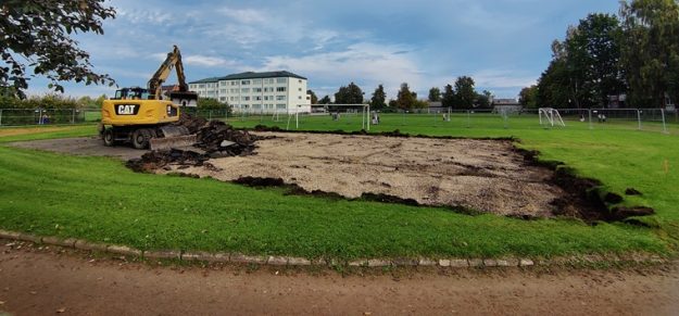 Asteru_iela_basketb_small Sporta laukumā pie Aspazijas vidusskolas notiek pārbūves darbi – zālājā redzama izrakta teritorija un ekskavators.