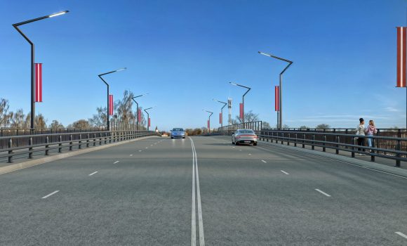 1_a-no-brauktruves-scaled Modernizēts tilta pārvads ar gludu asfaltu, jaunu apgaismojumu, Latvijas karogiem un gājēju celiņu brauktuves malās.