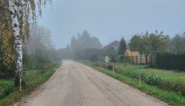 Burinu_cels Miglains meža ieskauts grants ceļš rudenī ar bērzu kreisajā pusē un privātmājām labajā malā.