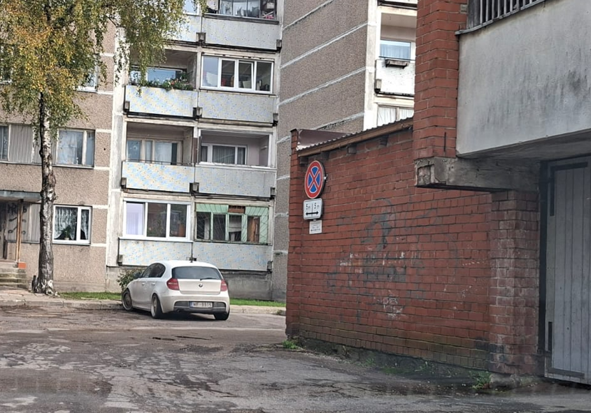 Daudzdzīvokļu mājas pagalms ar sarkana ķieģeļa piebūvi, ceļa zīmi 5 m attālumā no zīmes nenovietot auto uz abām pusēm.